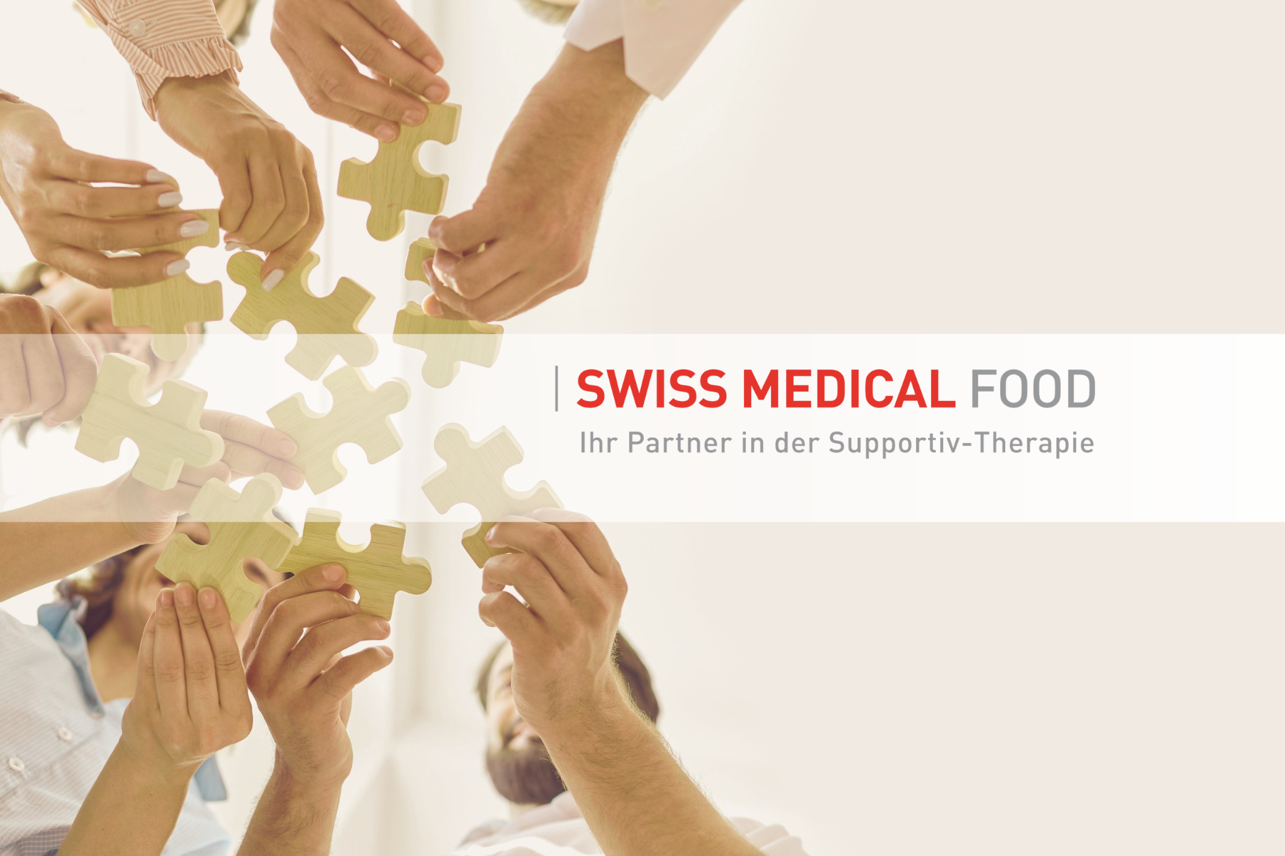Sieben Hände halten Puzzleteile in der Luft, Mission und Vision der Swiss Medical Food DE GmbH